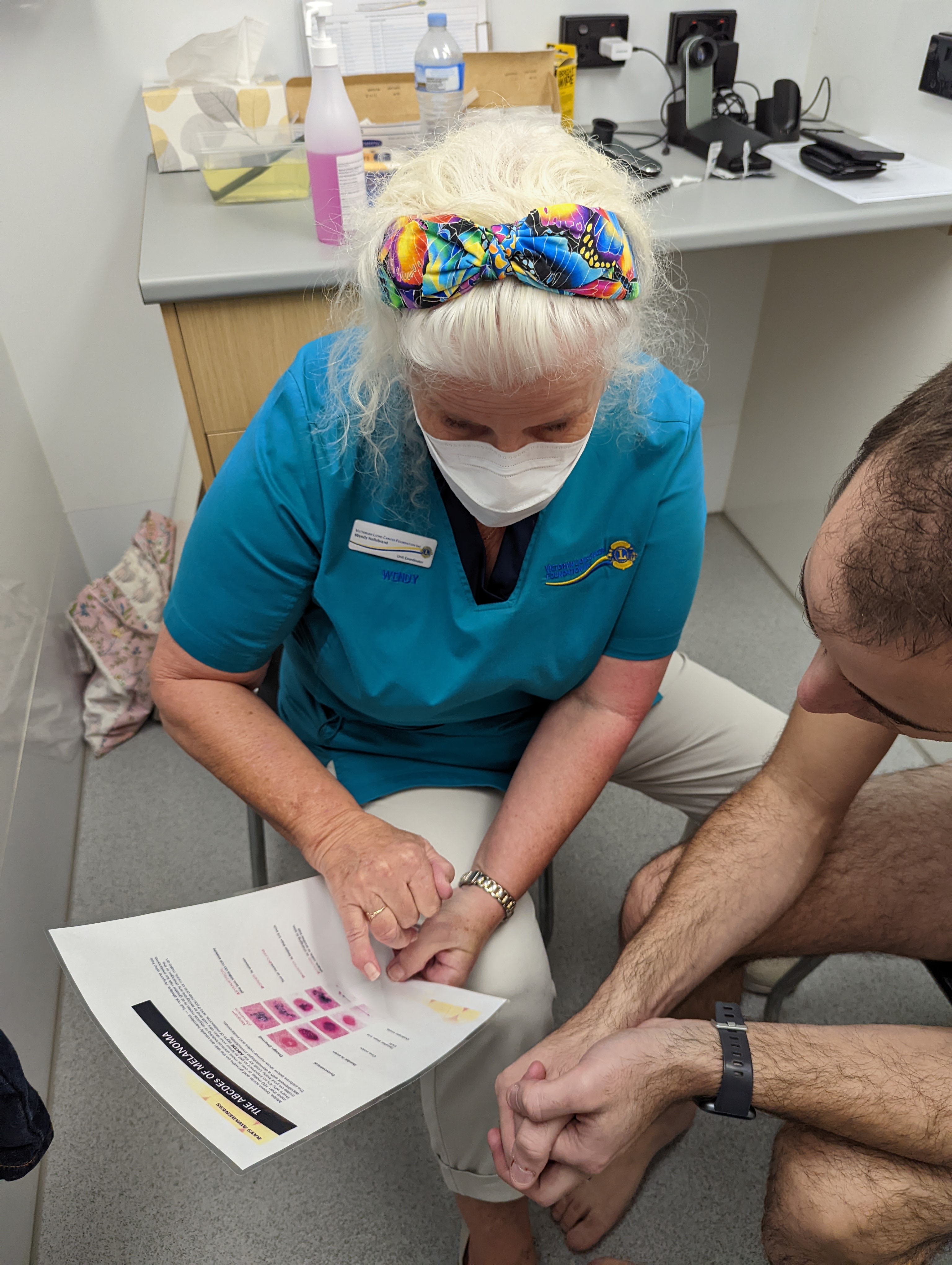 A equipe da unidade móvel de rastreamento do câncer consulta um paciente