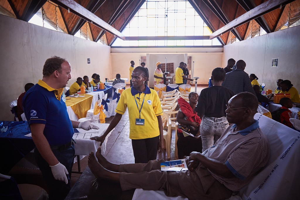 Dr. Fabien Collis, charter member of the Nairobi Phoenix Lions Club, consults with diabetic patient and clinic staff